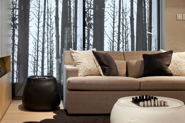 A large mural depicting a barren winter forest sets the mood in this contemporary living room. Warmth comes into play with warm wool upholstered sofa, velvet pillows in chocolate brown and grasscloth wall covering.