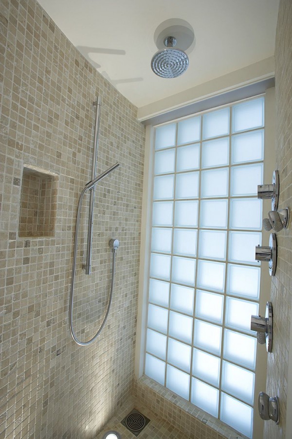 Glass blocks offer naturally lighting in the master shower with its luxury fixtures of rain shower head and multi-directional wall heads.