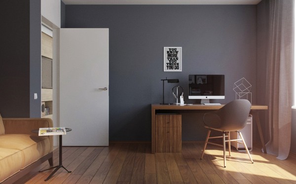 A view of the home office shows a simple yet richly grained wood desk and modern armchair in grey with natural wood base. The wide plank wood flooring adds to the warmth of the space.