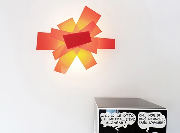 A backlit modern art sculpture of acrylic adds a touch of color to the otherwise black and white space.