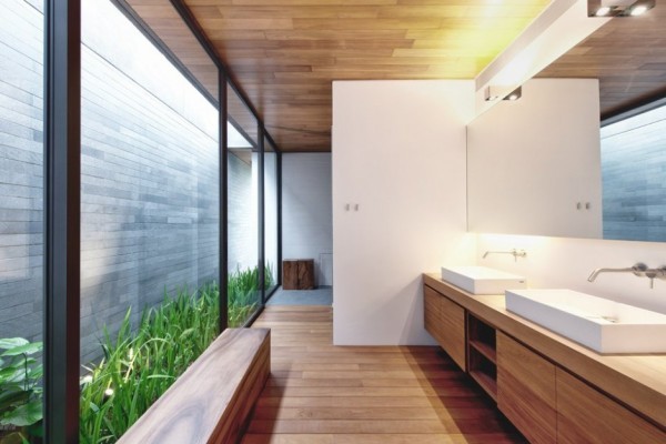 The master bathroom is warmed by use of organic golden hued wood on floor, ceiling and cabinetry.