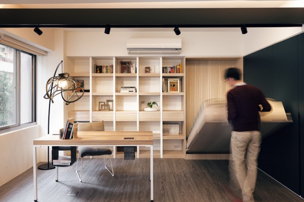 This modern office space quickly becomes a bedroom retreat with a Murphy bed hiding in the wall. It is a smart use of the space as even when the bed is set up, you're still able to function in the office without interference.
