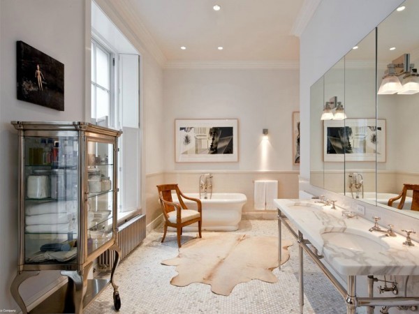 The bathroom is luxurious yet still keeps to the industrial feel with the exposed water pipes. It has modern lighting fixtures yet a traditional tub stand alone tub.