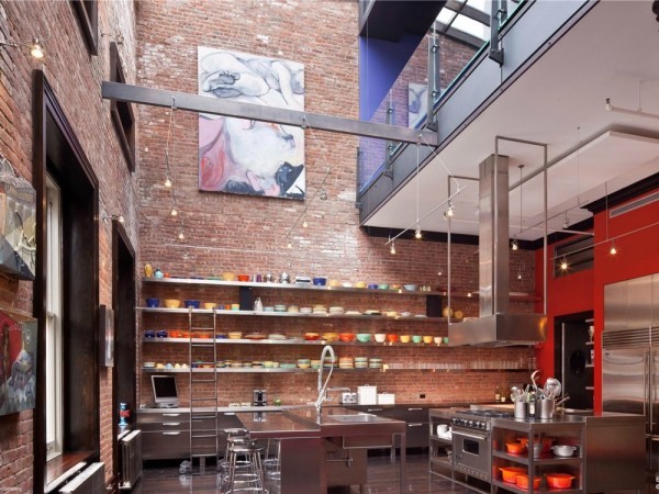 The kitchen is fit for a master chef with top of the line stainless steel appliances. The space is huge with a balcony overlooking the room. Rather than typical kitchen cabinets, the designers chose open shelving to store dishes.