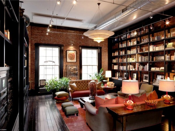 The dark hardwood warms the home while the exposed brick keeps it industrialized. The floor to ceiling book shelves make this one grand in-home library.