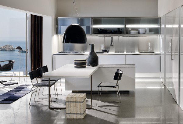 This kitchen space is also multi-functional with the dining table connected to the center island. The white walls and furnishings keep the design clean.