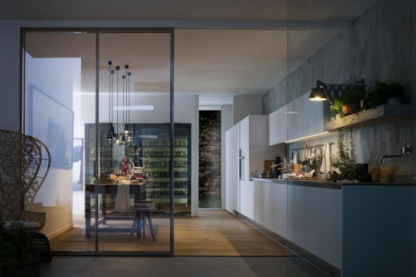 These kitchens have a linear range wall basically keeping the entire kitchen on one side of the room. It makes space for a good sized dining area. The glass walls provide separation without taking away the feel of a large, open space.