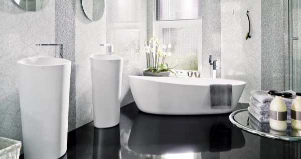 Mosaic tiles created an incredible pattern on the walls of this bathroom. Tall pedestal sinks and a freestanding tub dominate the room without overpowering it.