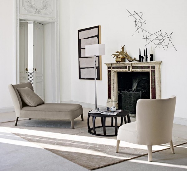 A cozy spot in front of the fire place is created here with a neutral chaise lounge and an armchair. The black in the table and accent pieces add a bit of contrast.