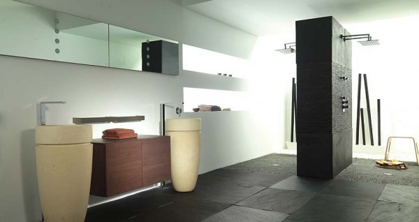 This bathroom has a lot of different colors, shapes and textures and yet it is all tied together to create a uniform look. The dark tile floors are beautiful and the pedestal cylindrical sinks are a creative alternate to your standard bathroom sink.