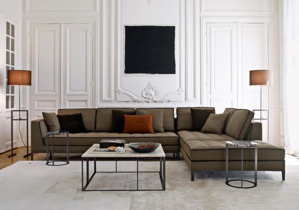 The same piece previously shown in a more subdued color gives another option for someone who isn't as adventurous with their design. This brown sectional with black trim provides contrast in this white room. The square coffee table and circular end tables have the same structural design, even if the shapes differ.