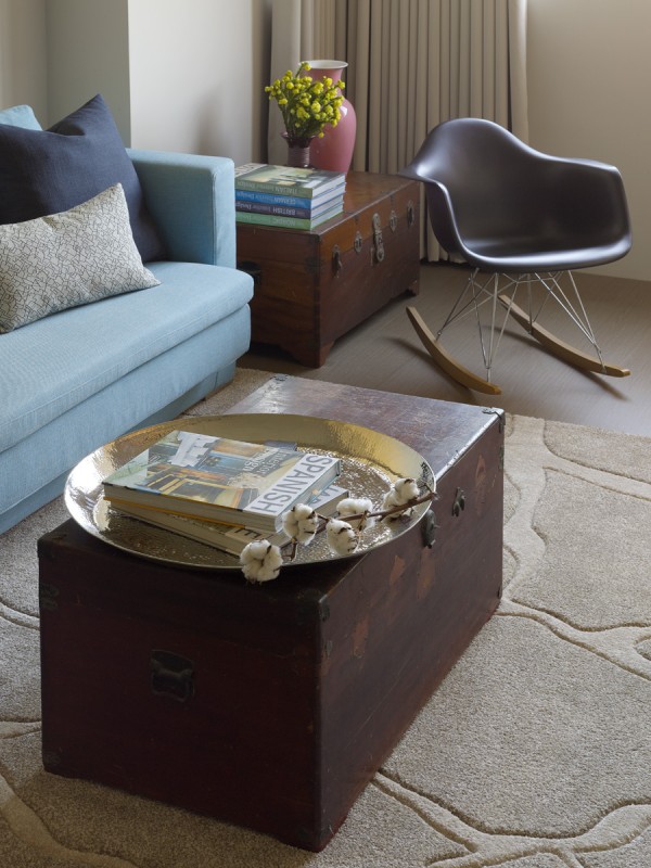 A pair of vintage trunks repurposed as tables give additional storage and a creative feel. The area rug, though a neutral color, brings in elements of nature in its rock pattern that mimics the bed of a flowing creek.