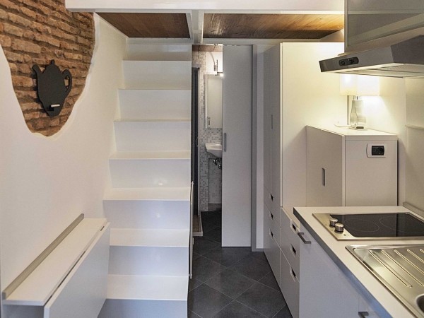 With the table tucked away, a narrow staircase leads up to the bedroom and living area, where a trapdoor can be closed behind you so you don’t accidentally slip back downstairs.