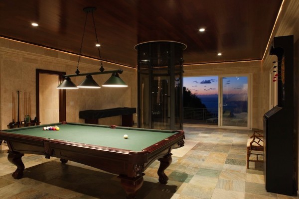 Located on the pool level of this three-level mansion is a game room, including billiards table along with a fully equipped wet bar and two guest suites.