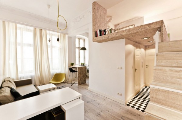 The key to any small apartment is making sure that you make use of vertical space. By tucking a bedroom up a set of narrow stairs, the designers create a makeshift second floor that frees up a lot more living space.