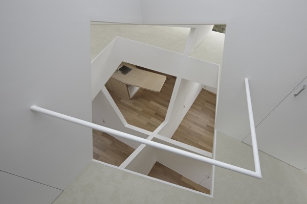 From a different angle, we can see how the "holes" in the floor offer a view all the way up and down, giving a clear impression of the cube theme that pervades the house.