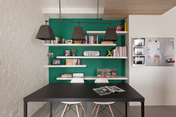 The green accent wall in the dining area is the only color focus. The darker, almost forest green shade gives it a more neutral and natural appeal.