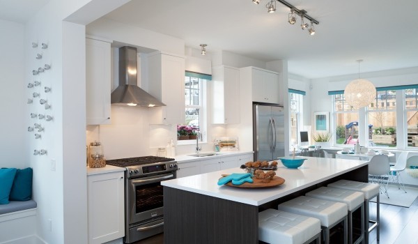 Tucking barstools under one side of a kitchen island is a classic space-saving technique. Tiny turquoise accents bring the rest of the room to life.