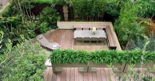 We love the feathery privacy screening created by the border of leafy green plants in this one, as well as the tropical jungle-like borders to make you feel as though you are sunbathing in the rainforest rather than perched above a concrete jungle. The decking runs from edge to edge, giving this space the feeling of an indoor room.