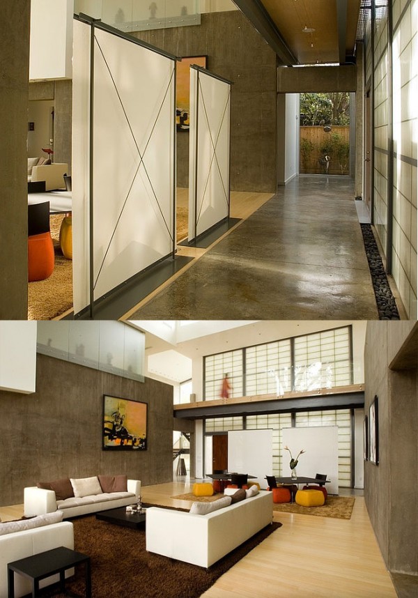 Translucent walls separate a concrete hallway from a contemporary living room with a Japanese flair.