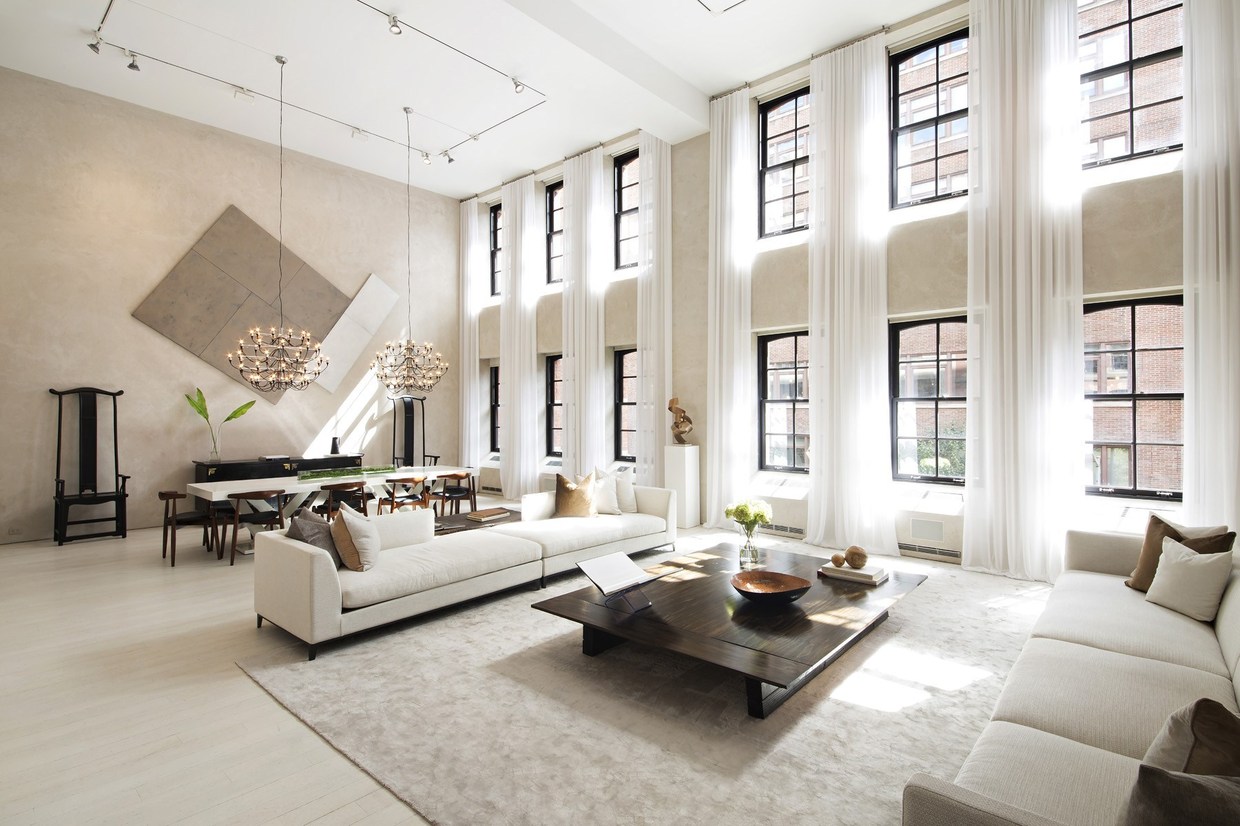 This apartment occupies a generous 6,471 square foot floor plan centered on a great room with a double-height ceiling, its lovely neutral interior flooded with light from windows that span the 17'5" walls. The current design maintains the characteristic industrial details from the property's former life, setting the stage for a glamorous modern interior in line with today's minimalist tastes. Track lighting, spectacular chandeliers, and eye-catching artwork offer abundant interior decor inspiration. 