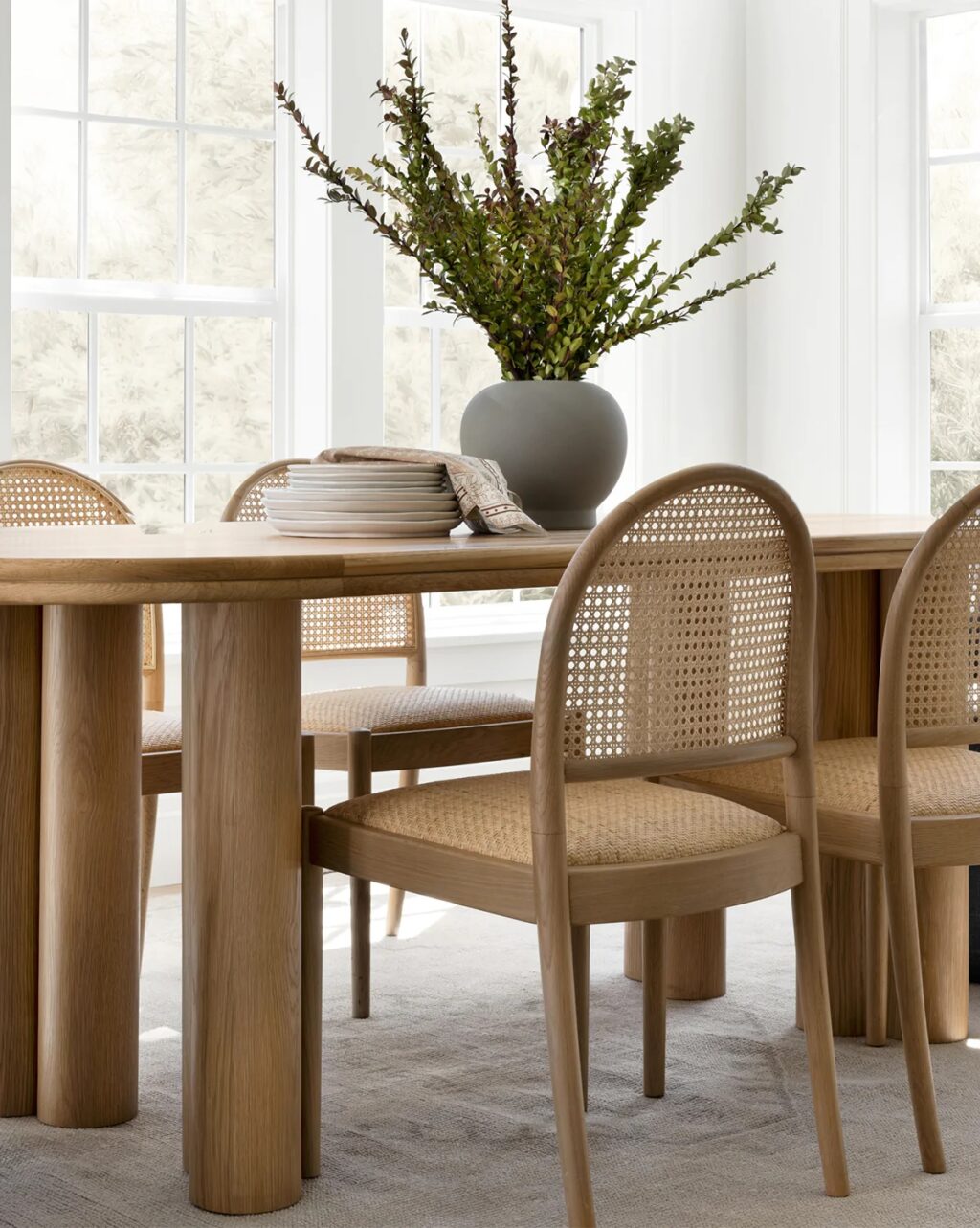 modern natural cane dining chair design with arched backrest and woven