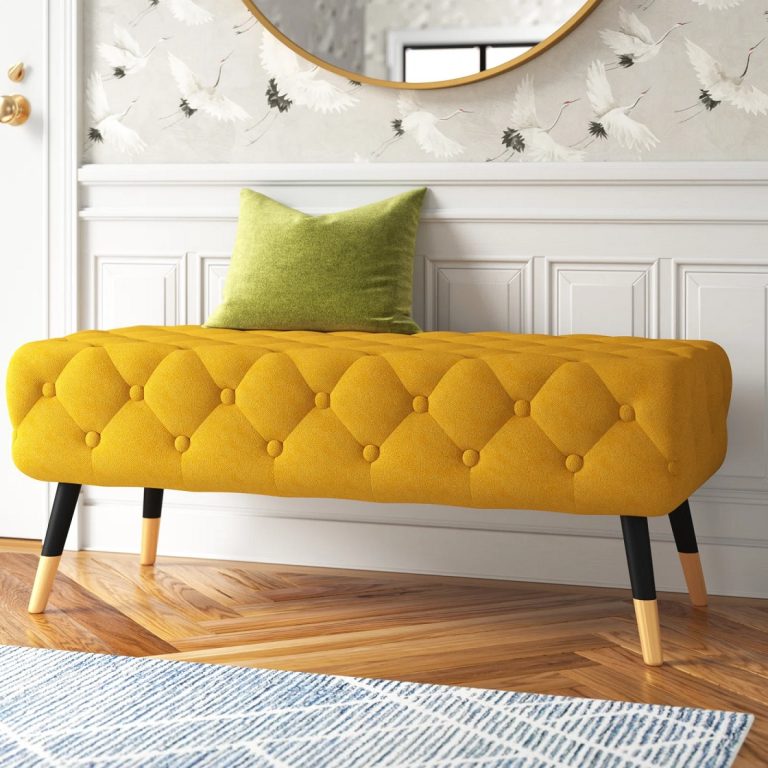 bright yellow tufted bench with black legs and gold capped feet