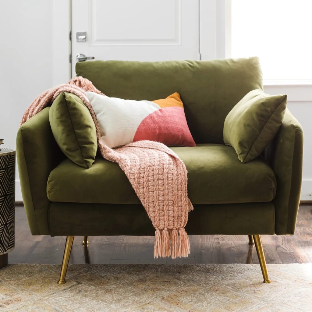 wide green velvet accent chair with removable side cushions and gold